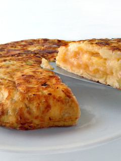 Una foto de Tortilla de patatas con queso de cabra y cebolla caramelizada