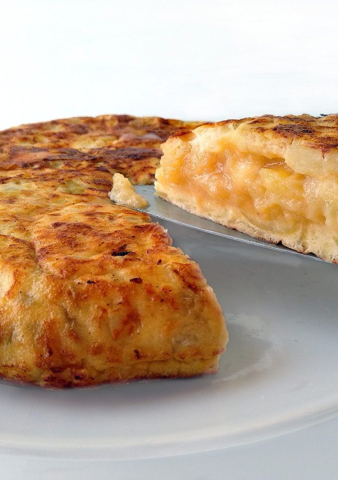 Una foto de Tortilla de patatas con queso de cabra y cebolla caramelizada