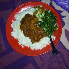 A picture of White rice and stew with steamed veggies.
