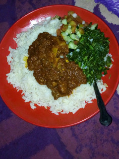 A picture of White rice and stew with steamed veggies.