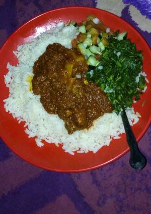 A picture of White rice and stew with steamed veggies.