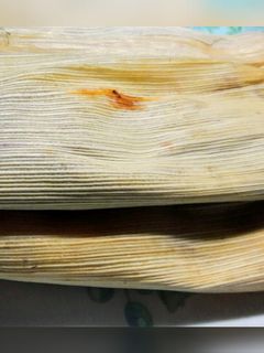 Una foto de Tamales de mole negro con pollo