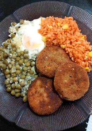 Una foto de Hamburguesas de pescado acompañadas de arroz y guisantes