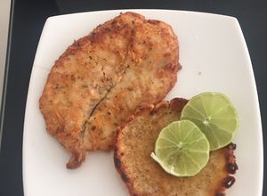 Una foto de Filete de pescado apanado con queso parmesano y orégano