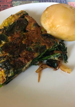Una foto de Omelette volteado de espinacas y cebollas