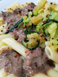 Una foto de Macarrones con salsa de morcilla y crujiente de calabacín