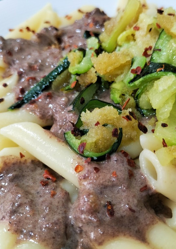 Una foto de Macarrones con salsa de morcilla y crujiente de calabacín