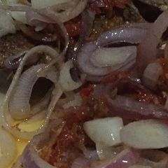 A picture of Fried Tilapia fish with onion sauce.