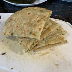 A picture of Chinese Scallion Pancake (葱油饼) (cōng yóu bǐng).