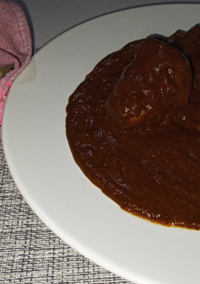 Una foto de Mole Oaxaqueño con pollo y tortillas de maíz hechas a mano