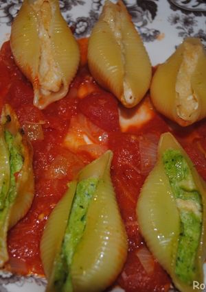 A picture of Stuffed pasta shells with cheese and spinach.