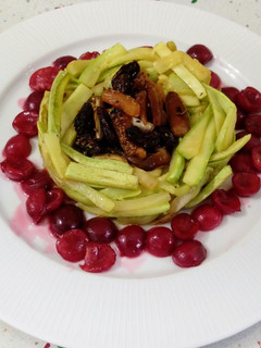 Una foto de Nido de calabacines salteados con frutas secas y cerezas salteadas con patxaran