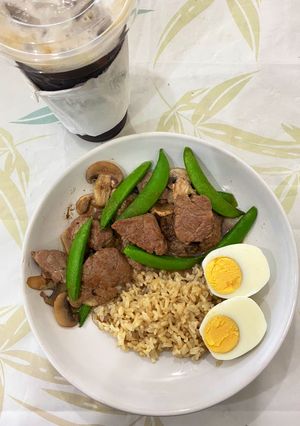 A picture of Stir-fried beef with sugar snap pea and mushroom on rice.
