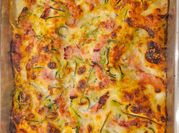 Una foto di lasagna con prosciutto cotto