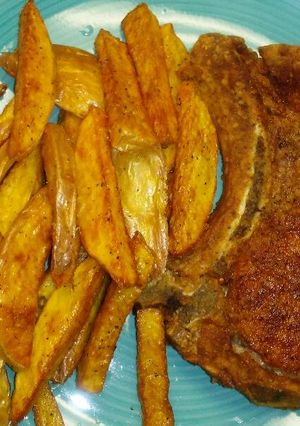 A picture of Pork Chops& Seasoned Fries.