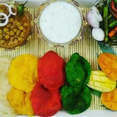 A picture of Choley with Colourful Poorie and Cucumber Raita.