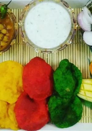 A picture of Choley with Colourful Poorie and Cucumber Raita.