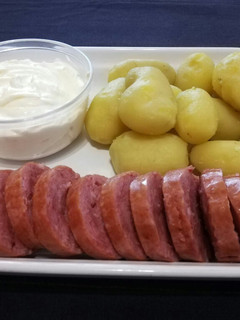 Una foto de Patatas y salchichas al vapor con salsa agria de queso