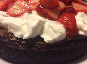A picture of Decadent Chocolate Cake with Fresh Strawberries and Whipped Cream.