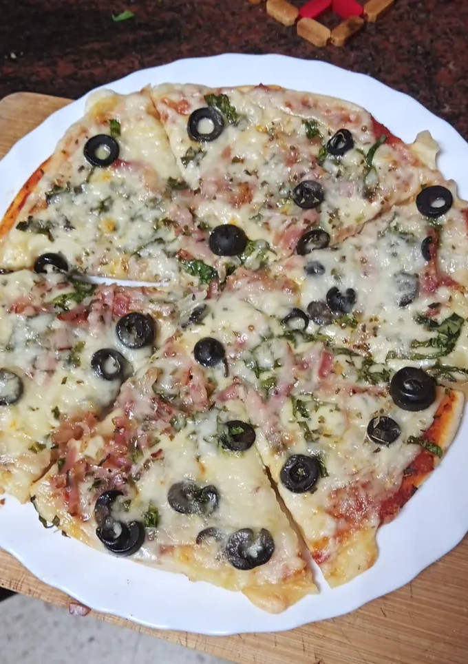 Una foto de Pizza de espinacas, cebolla, bacon y aceitunas negras