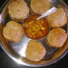A picture of Aloo tamatar with puri.