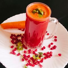 A picture of Pomegranate seeds with carrot juice.