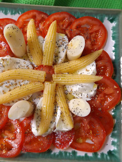 Una foto de Tomates, mazorquitas, palmitos y mozzarella con semillas de amapola