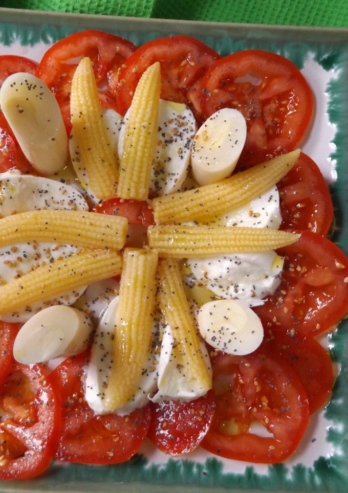 Una foto de Tomates, mazorquitas, palmitos y mozzarella con semillas de amapola