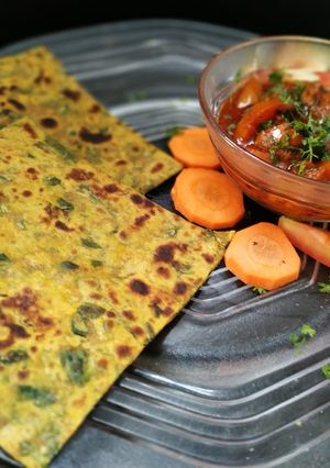 A picture of Methi ka paratha with tomato chutney.