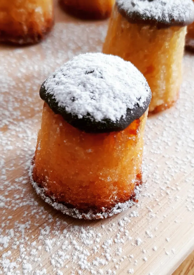 Una foto de "Canneles" v1 de almendra, rellenos de crema y con chocolate s/g