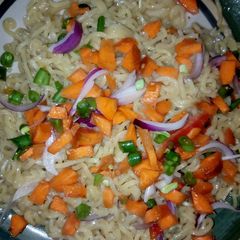 A picture of Stir fried Noodles garnished with veggies.