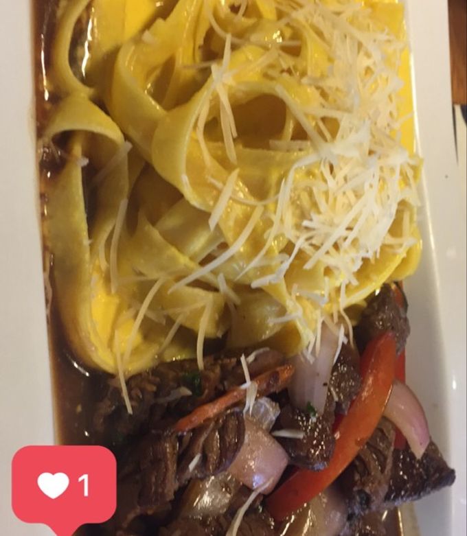 Una foto de Lomo saltado con fettuccine a la huancaina