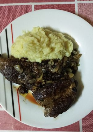 Una foto de Churrascos de hígado encebollado con puré de papas