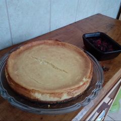 A picture of New york style Cheesecake with berry reduction.