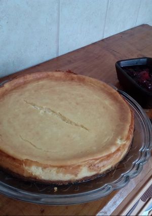A picture of New york style Cheesecake with berry reduction.