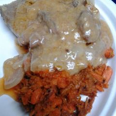 A picture of Butter gravy smothered sirloin with mashed carrots.