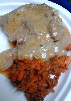 A picture of Butter gravy smothered sirloin with mashed carrots.