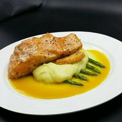 A picture of Seared salmon/mashed potatoes served with orange white wine sauc.