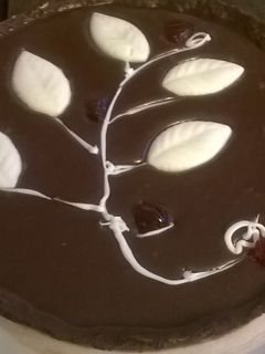 Una foto de Tarta de ganache de chocolate, dulce de leche y cerezas