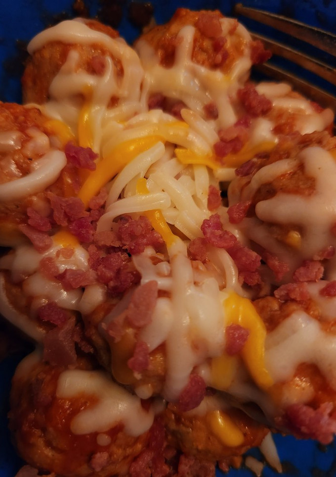 Una foto de Albóndigas con salsa, queso y bacon