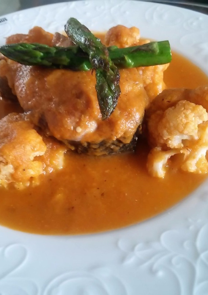 Una foto de Coliflor con postas de pescado en salsa de tomate, puerro y espárragos