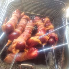 A picture of Deep-Fried, Bacon-Wrapped Hot Dogs on Skewers.