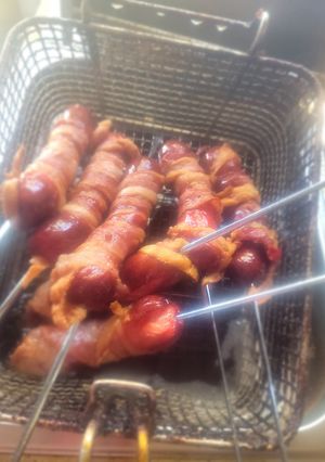 A picture of Deep-Fried, Bacon-Wrapped Hot Dogs on Skewers.