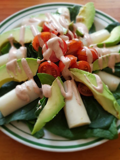 Una foto de Ensalada de palmitos, aguacate y tomate con salsa golf