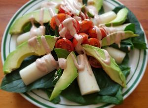 Una foto de Ensalada de palmitos, aguacate y tomate con salsa golf