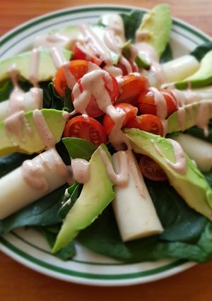 Una foto de Ensalada de palmitos, aguacate y tomate con salsa golf