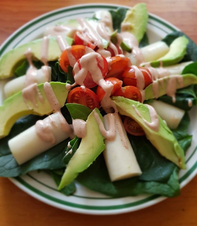 Una foto de Ensalada de palmitos, aguacate y tomate con salsa golf