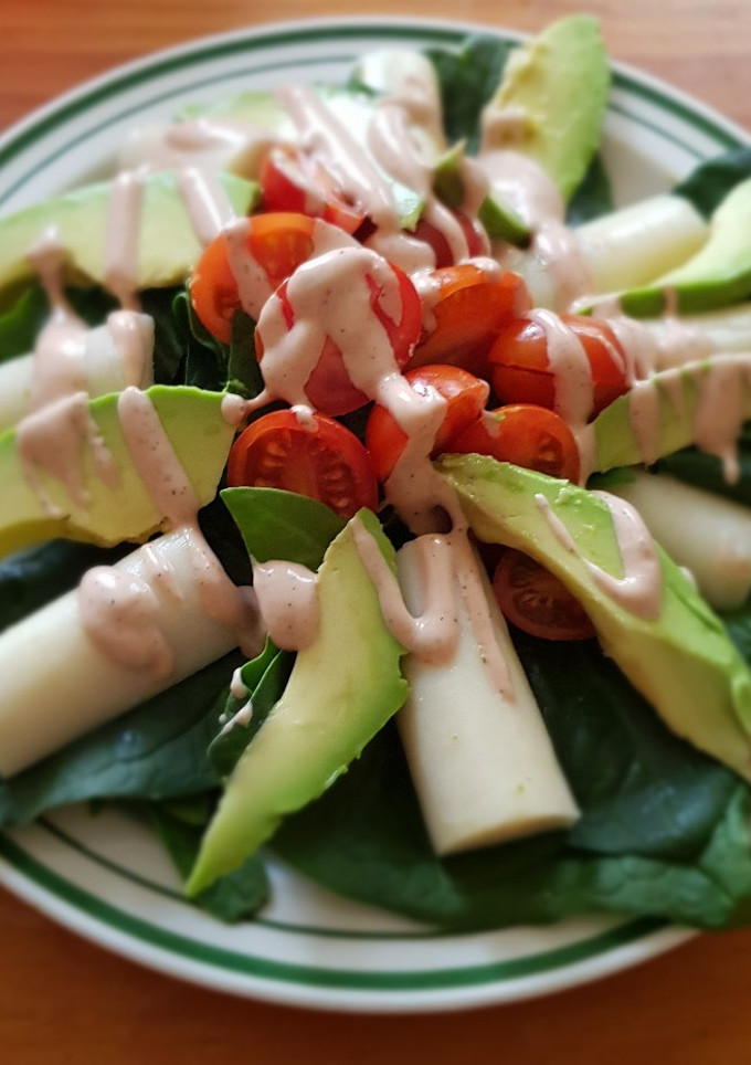 Una foto de Ensalada de palmitos, aguacate y tomate con salsa golf