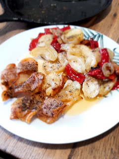 Una foto de Secreto Ibérico con patatas, cebolla y pimiento rojo
