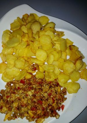 A picture of Fried potatoes with scramble egg sauce.